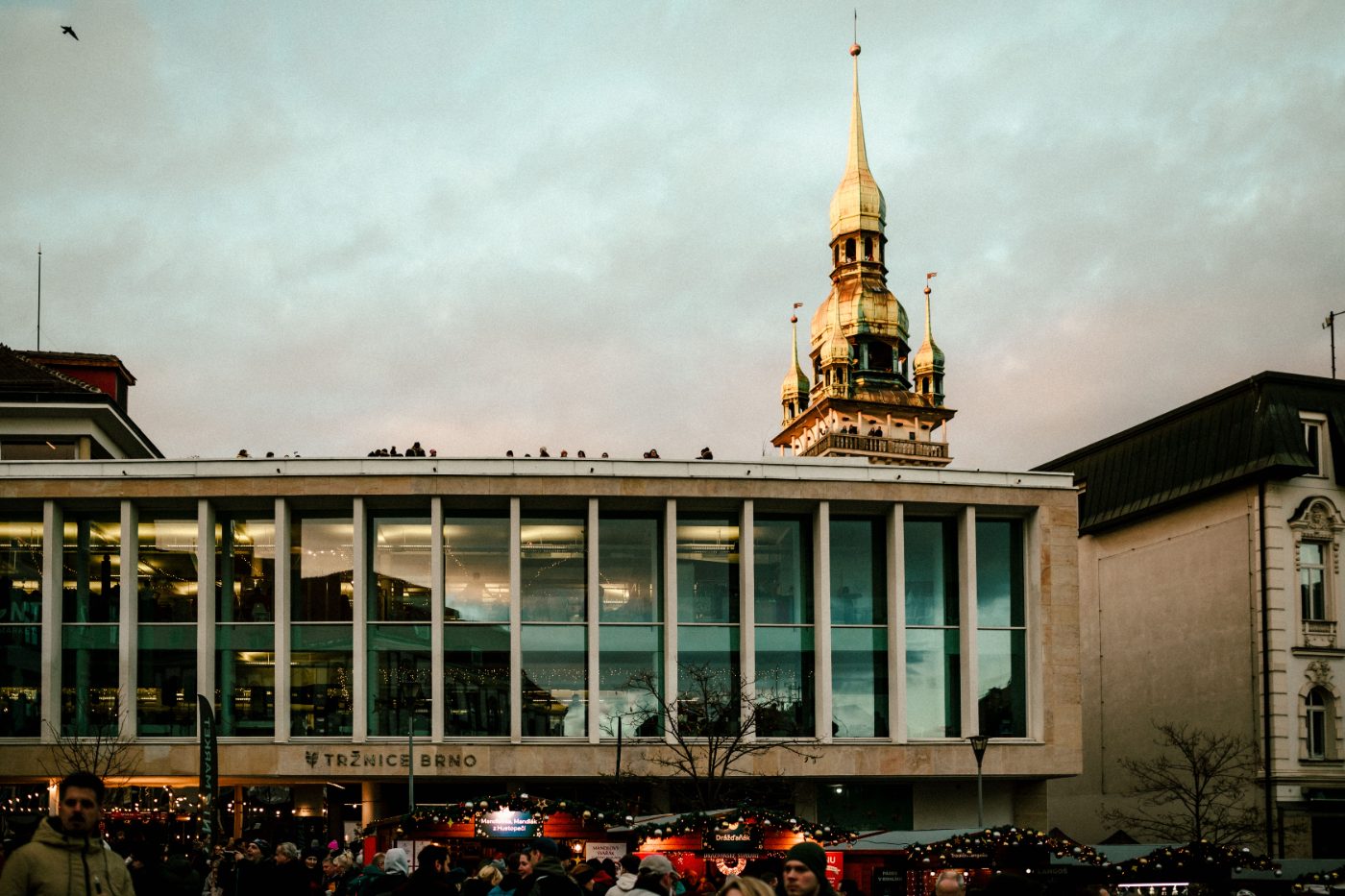 Vibrant city scene in Brno, featuring architecture and bustling street life at twilight.