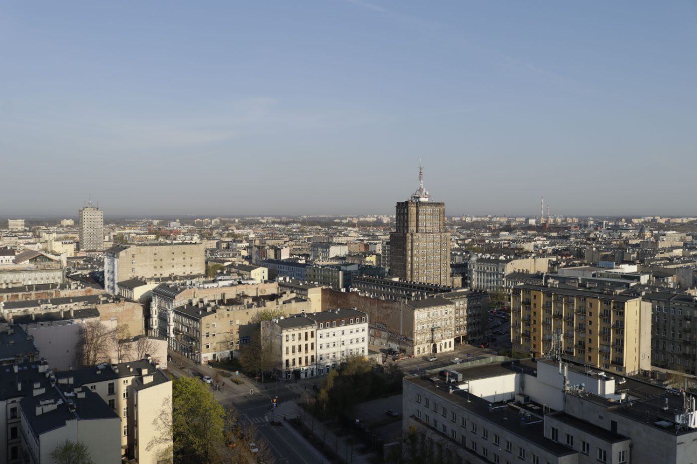 Aerial shot capturing a sprawling cityscape with varied architecture in daylight.