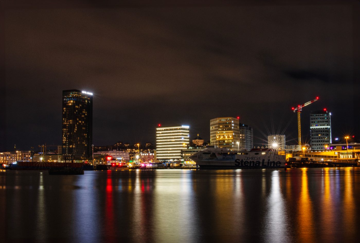 Illuminated cityscape of Göteborg with Stena Line ferry at night.