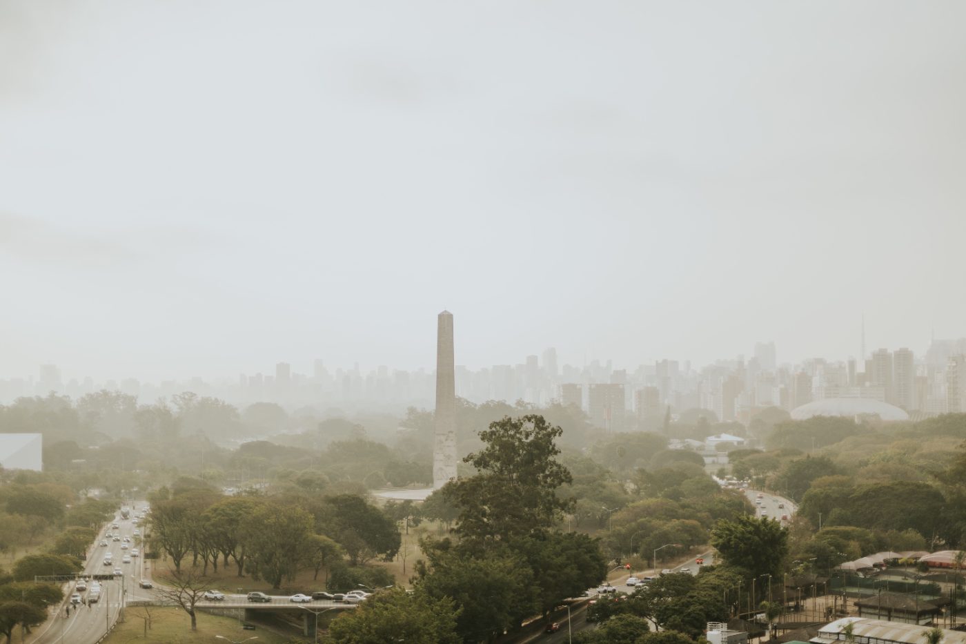 Aerial shot of Obelisk in Ibirapuera Park, São Paulo, surrounded by lush greenery and cityscape.