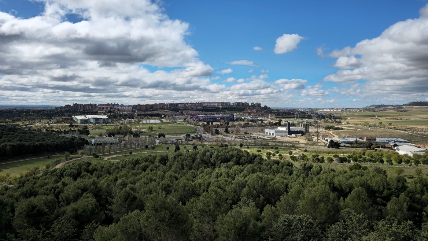 Aerial view of Valladolid, Castile and León, Spain featuring lush greenery and urban backdrop under a bright sky.